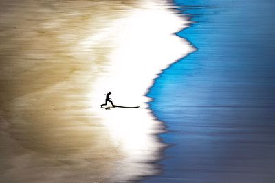 Silhouette people by sea