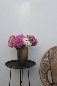 Close-up of flower vase on table against wall