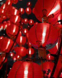 Low angle view of illuminated lanterns hanging against sky at night