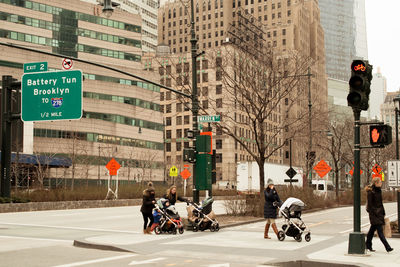 People on road against buildings in city