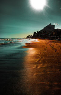 Scenic view of beach by buildings against sky