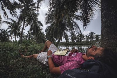 Woman lying down on palm tree