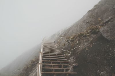 Low angle view of steps against sky during foggy weather