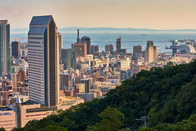 Cityscape by sea against sky in city