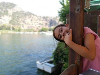 Portrait of girl standing against lake