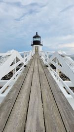 Lighthouse by sea against sky