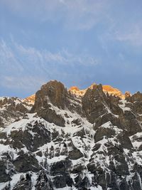 Low angle view of snowcapped mountains against sky