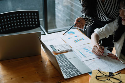 Midsection of business colleagues working on table