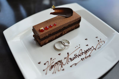 High angle view of rings and cakes on plate during wedding anniversary