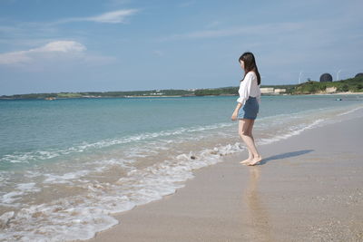 Full length of woman on beach against sky