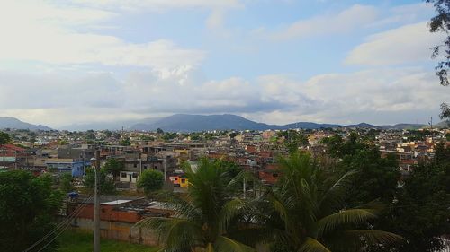 Aerial view of city against cloudy sky