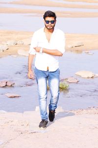 Portrait of young man standing on beach