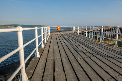 Pier over sea against clear sky