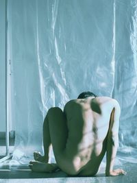 Midsection of woman sitting on bed