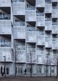 Man walking on road by building