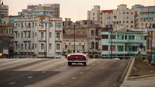 Vehicles on road against buildings in city