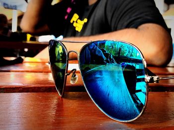 Close-up of person wearing sunglasses on table