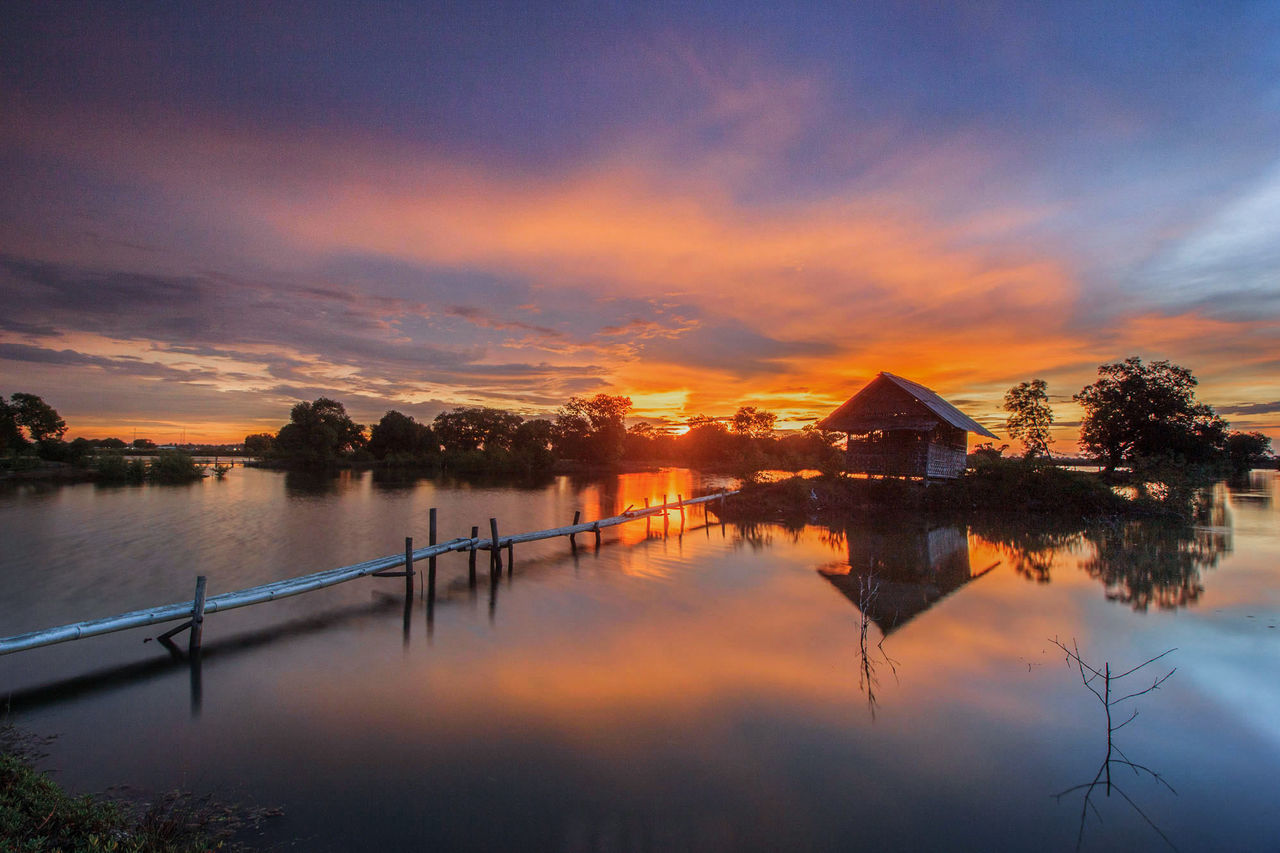 sunset, water, reflection, sky, built structure, architecture, tranquil scene, tranquility, beauty in nature, scenics, outdoors, nature, building exterior, cloud - sky, lake, silhouette, no people, tree, day