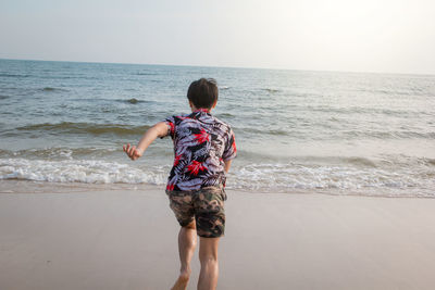 Rear view of boy on beach