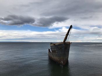 Fishing boat in sea against sky