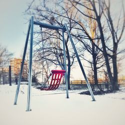 Bare trees on snow covered playground