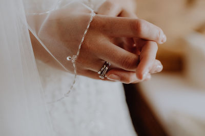 Midsection of bride with hands clasped