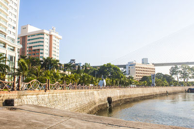 Buildings by swimming pool against sky in city