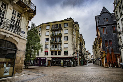 Street amidst buildings in town against sky