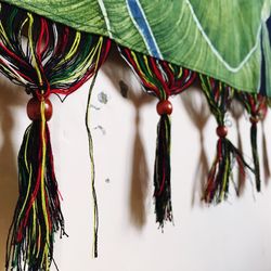 Close-up of curtain tassels against wall