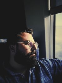 Man looking away while sitting by window in train