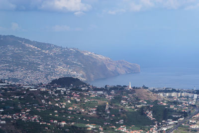 High angle view of townscape by sea against sky