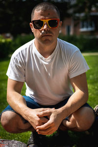 Portrait of a young man in belgian flag sunglasses.