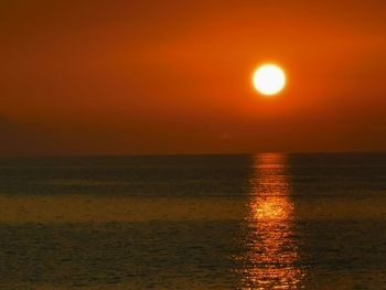 Scenic view of sea against orange sky