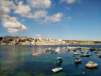 Sailboats moored in sea against sky