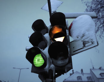 Low angle view of road signal against sky