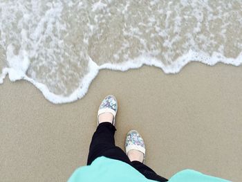 Low section of woman standing on beach