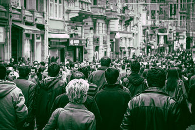 Rear view of people standing on street in city