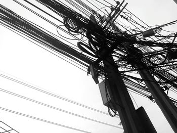 Low angle view of electricity pylon against clear sky