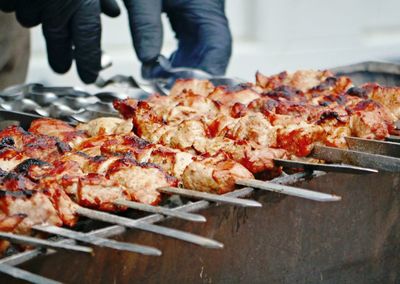 Close-up of person preparing food on barbecue grill