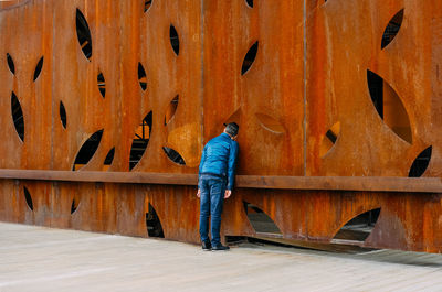 Rear view of man standing against wall