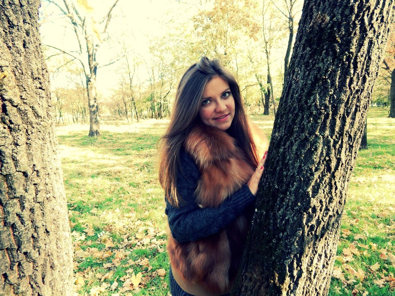 young adult, portrait, looking at camera, young women, tree, person, front view, lifestyles, tree trunk, leisure activity, long hair, standing, casual clothing, smiling, forest, three quarter length