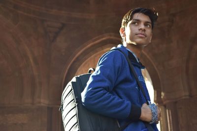 Portrait of young man looking away while standing in building