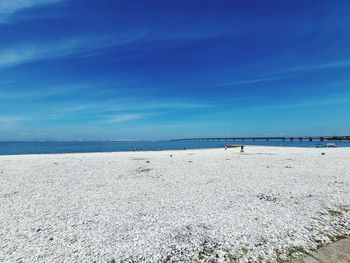 Scenic view of beach against blue sky