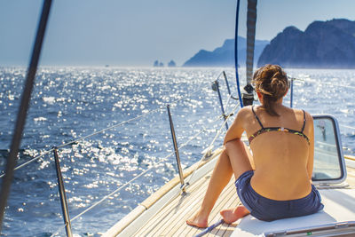 Rear view of woman looking at sea against sky