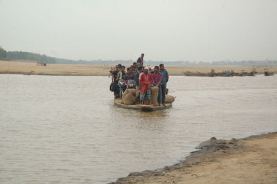 People in sea against clear sky