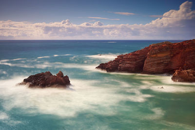 Rocks in sea against sky