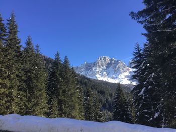 Scenic view of snow covered mountains against clear blue sky