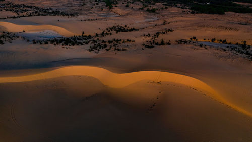 High angle view of sand dunes in desert during sunset