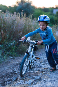 Boy riding bicycle in mud