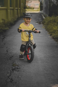 Portrait of cute 2 year old toddler riding a push bike